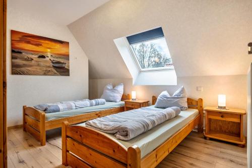 two beds in a room with a window at Ferienwohnung Dornhege in Borken