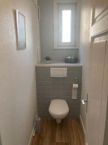 Elle comprend une petite salle de bains pourvue de toilettes et d'une fenêtre. dans l'établissement Appart tout confort à 100m de la plage de Malo., à Dunkerque