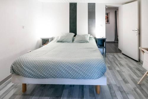 une chambre avec un grand lit dans une pièce dans l'établissement Appartement le JuTiNi, à Caunes-Minervois