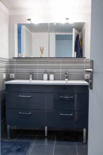 une salle de bain avec un lavabo bleu et un miroir dans l'établissement Appartement le JuTiNi, à Caunes-Minervois