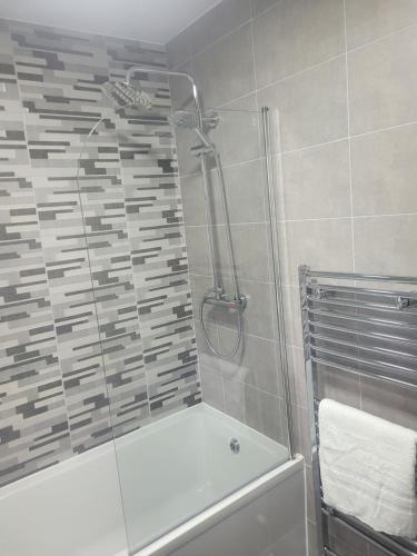 a bathroom with a shower and a bathtub with a glass door at NB's Cozy Nook, WIGAN in Shevington