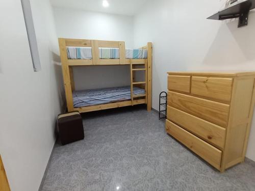 Cette chambre comprend 2 lits superposés et une commode. dans l'établissement APARTAMENTOS CON PISCINA Y ACCESO A PLAYA, à Cerro Azul