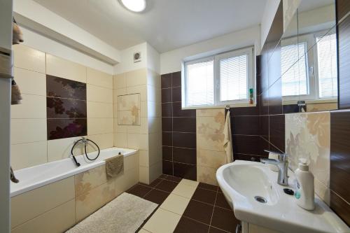 ein Badezimmer mit einem Waschbecken, einer Badewanne und einem Waschbecken in der Unterkunft Relax apartment Bratislava in Bratislava