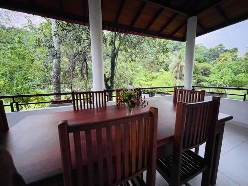 a dining room with a table and chairs on a porch at Su Yu villa in Unawatuna