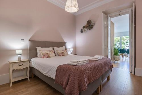 Un dormitorio con una cama y una mesa con toallas. en Apartamento Moderno com Terraço en Lisboa