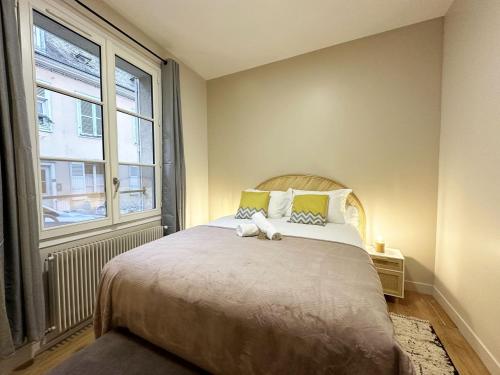 une chambre avec un grand lit et une fenêtre dans l'établissement Le Saint Julien - City center - Self-entrance, à Chartres