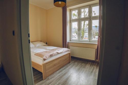 a small bedroom with a bed and a window at Apartamenty ABRACADABRA in Ustroń