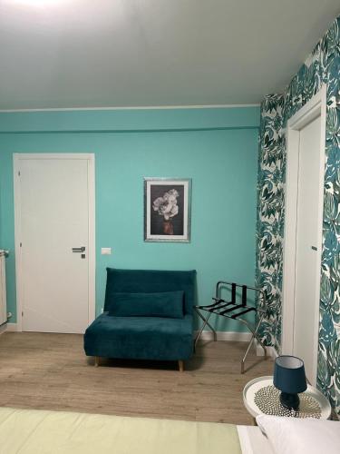 sala de estar con sofá verde y paredes azules en Casa flowers 1 en Ciampino