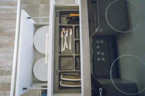 a drawer in a cupboard with some plates and aktop at Apartamenty ABRACADABRA in Ustroń