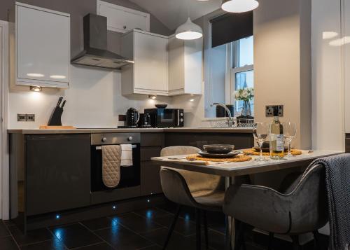 a kitchen with a counter with chairs and a table at Windsor Court in Brighton & Hove