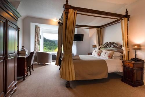 a bedroom with a canopy bed and a desk at Aberconwy House B&B in Betws-y-coed