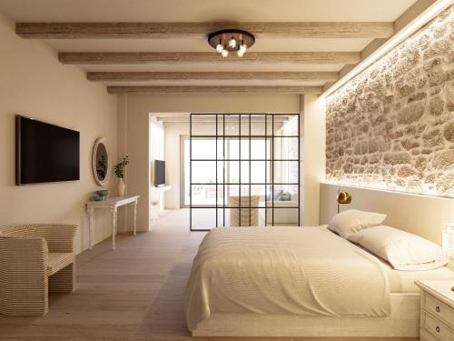 um quarto com uma grande cama branca e uma parede de pedra em Lofos Apartments em Hersonissos