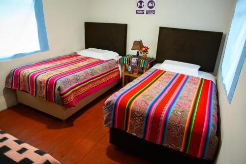 dos camas sentadas una al lado de la otra en una habitación en Quinuawasi House, en Ocosuyo