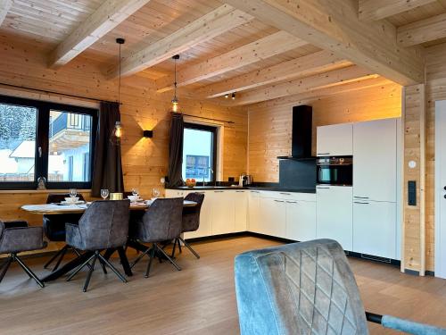 a kitchen and dining room with a table and chairs at Clofers Nature Chalets Obermöschach in Hermagor