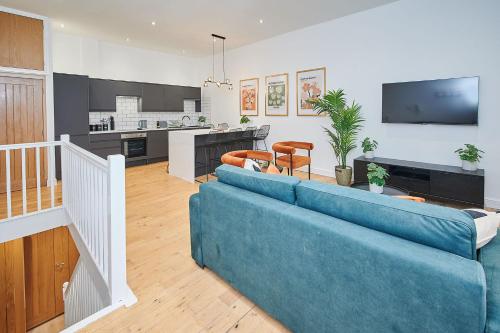 a living room with a blue couch and a kitchen at Host & Stay - Princes Place Hideaway in Liverpool