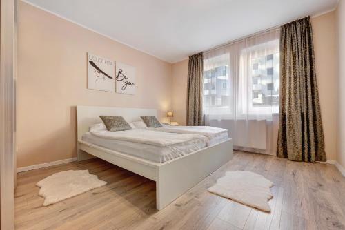 um quarto branco com uma cama e uma janela em Charmante Wohnung em Hanôver