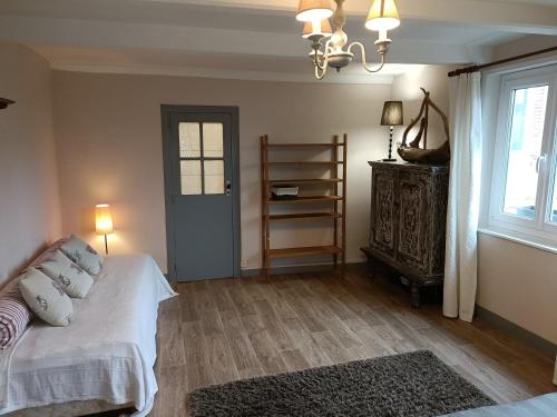 um quarto com uma cama com lençóis brancos e uma janela em Lovely cottage in Honfleur center em Honfleur