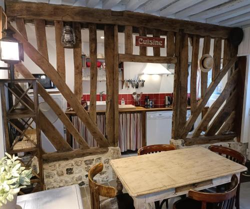 a kitchen with a wooden table in a room at Lovely cottage in Honfleur center in Honfleur
