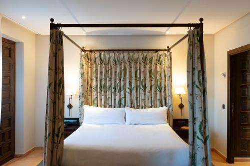 a bedroom with a canopy bed with white pillows at Parador de Sos del Rey Católico in Sos del Rey Católico