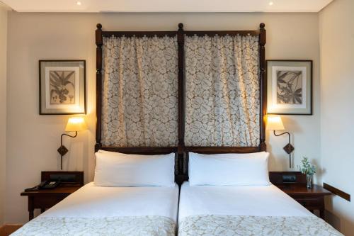 a bedroom with two beds and two lamps at Parador de Sos del Rey Católico in Sos del Rey Católico