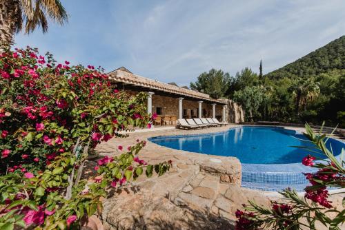 una casa con piscina e alcuni fiori di Paissa d'en Bernat a Cala Tarida