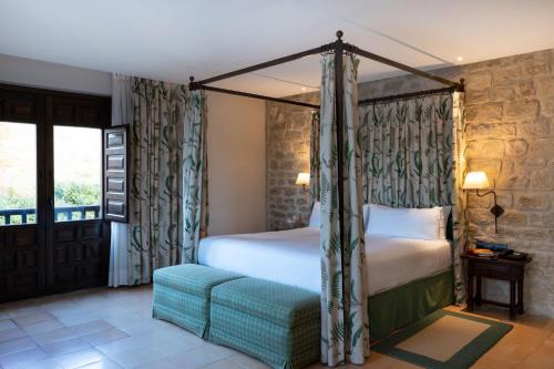 a bedroom with a canopy bed and a couch at Parador de Sos del Rey Católico in Sos del Rey Católico