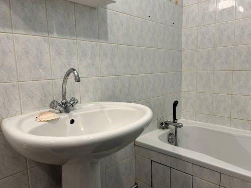 une salle de bain avec un lavabo et une baignoire dans l'établissement 537 - Studio les pieds dans l'eau, en bordure de la plage du centre d'Erquy, à Erquy