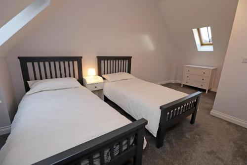 2 Betten in einem kleinen Zimmer mit in der Unterkunft Royal Hillsborough Village Luxury Townhouse in Hillsborough