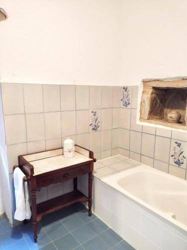 La salle de bains est pourvue d'une baignoire et d'une table à côté. dans l'établissement Maison de village PIEDICORTI DI GAGGIO, à Sortipiani
