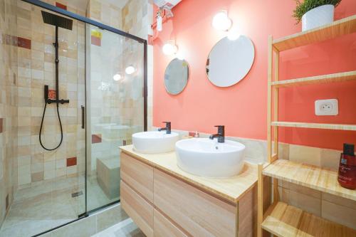 une salle de bain avec deux lavabos et une douche dans l'établissement Parisuites Central Canal Saint Martin Luxe & Chic & Cosy, à Paris