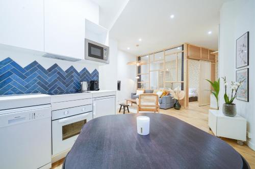 une cuisine avec une table et un salon dans l'établissement Parisuites Central Canal Saint Martin Luxe & Chic & Cosy, à Paris