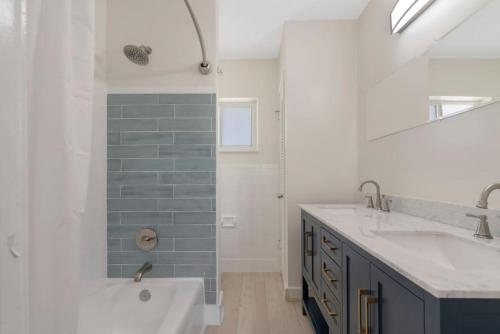 een badkamer met een bad, een wastafel en een douche bij Unit 4 Spacious 1 bedroom Apartment with 70inch smart TV in Fort Lauderdale