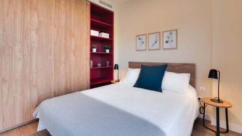 1 dormitorio con 1 cama y estante de libros rojo en Livensa Living Studios Madrid Alcobendas en Alcobendas