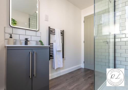 a bathroom with a sink and a mirror at Comfy Modern 2 Bed near Glenfield Hospital, sleeps up to 6 in Glenfield