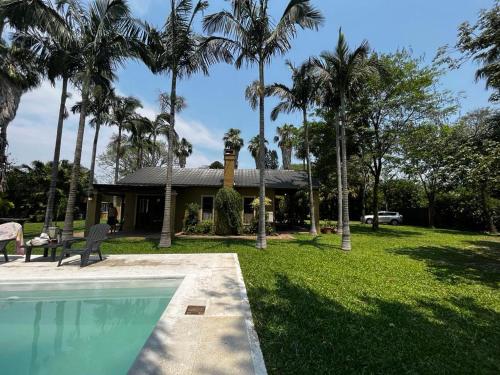 a house with a swimming pool and palm trees at La Quinta in Corrientes