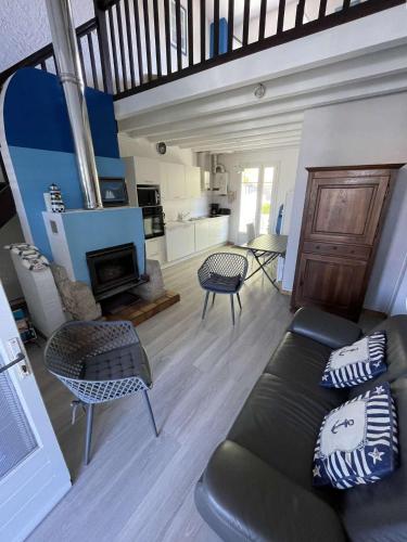 - un salon avec un canapé, des chaises et une cheminée dans l'établissement Réf 277 Seignosse LES BOURDAINES , à proximité immédiate de la plage, Villa patio classée 2 étoiles , 8 personnes, à Seignosse