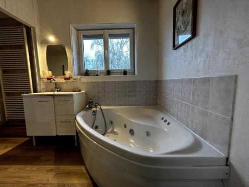 a large white tub in a bathroom with a sink at My Pommery#reims in Reims