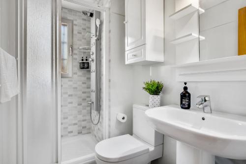y baño blanco con lavabo y ducha. en Golondrina by IVI Real Estate, en Torremolinos