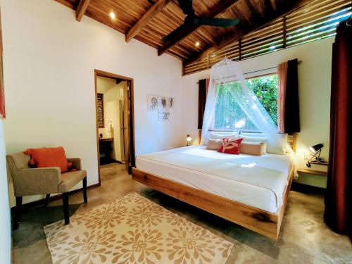 a bedroom with a large bed and a window at Satta Lodge in Puerto Viejo