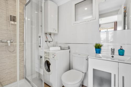 トレモリノスにあるVistamarina A201 by IVI Real Estateの白いバスルーム(トイレ、シャワー付)
