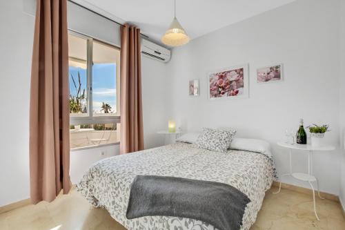 トレモリノスにあるVistamarina A201 by IVI Real Estateの白いベッドルーム(ベッド1台、窓付)