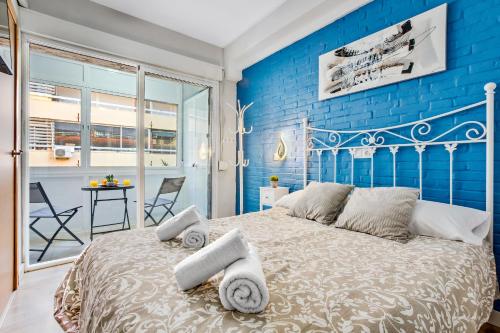 a blue bedroom with a large bed with towels on it at Los Nidos 603 By IVI Real Estate in Torremolinos