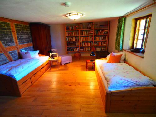 two beds in a room with bookshelves at Eulenhof Vorpommern in Rossin