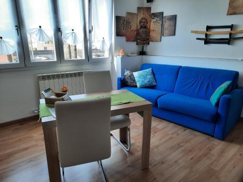 a living room with a blue couch and a table at Appartamento Yuki in Dervio