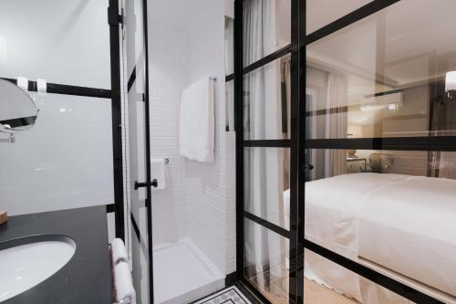 uma casa de banho com um lavatório e uma cama em AlmaLusa Alfama em Lisboa