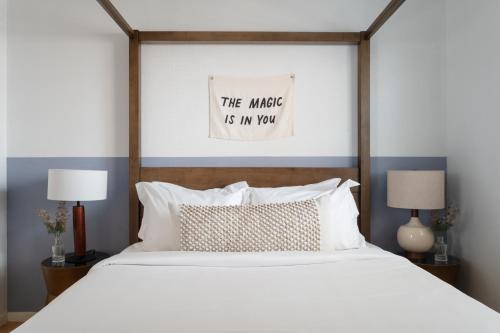 a bedroom with a white bed with a poster on the wall at Locale Bouldin Creek - Austin in Austin