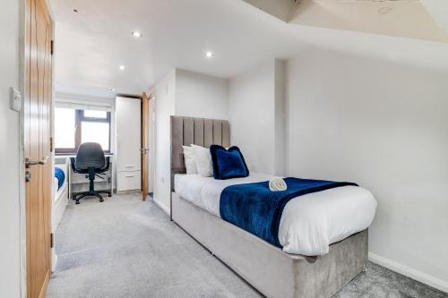 um quarto com uma cama com uma almofada azul em LiveStay - Stylish 3-Bed Gem in Trendy E1 London em Londres