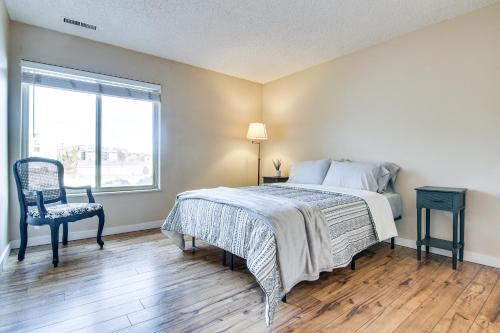 a bedroom with a bed and a chair and a window at Colorado Springs Condo with Fireplace Near Downtown in Colorado Springs
