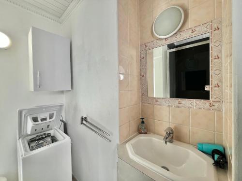 une salle de bain avec une baignoire, un lavabo et un miroir dans l'établissement Louise appartement, by Welcome to Cannes, à Cannes