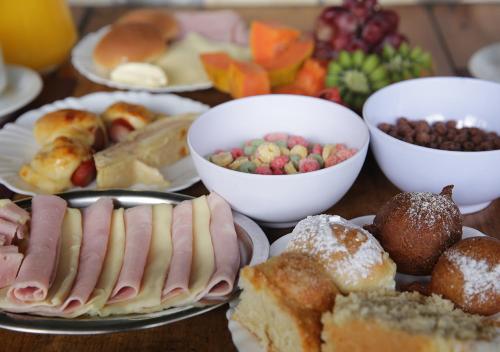 a table full of different types of food on plates at Vale Encantado - Eco Park & Hotel in Biritiba-Mirim